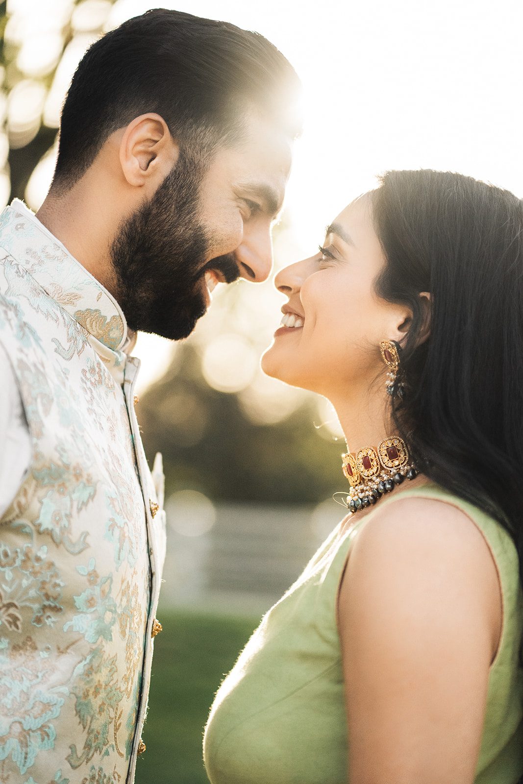 Couple in traditional attire sharing a golden-hour moment outdoors